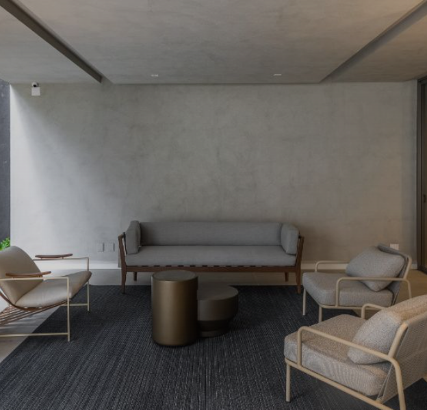 Sala de estar de um apartamento Noon, com sofá, poltronas e janelas amplas